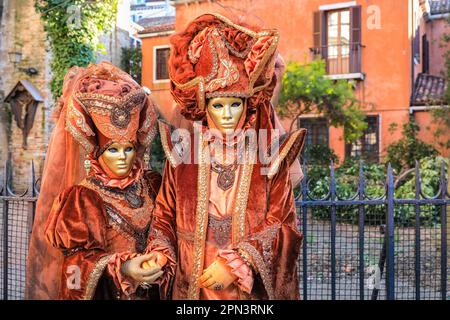 Venice Carnival, female participants in Venetian baroque costumes and masks with elaborate hat, Venezia Italy Stock Photo