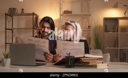 Couple study learning economics charts graphs home Stock Photo