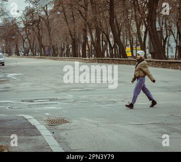 Girl walking down the street. Woman on crossroads in downtown. Autumn in the city. Big city lifestyle. Street fashion. Urban lifestyles. Stock Photo