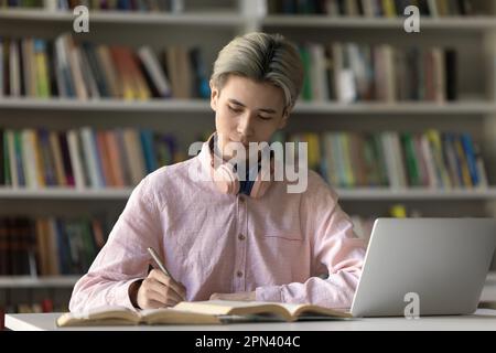 Diligent Asian male student studying in library Stock Photo