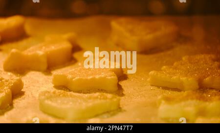 Process of baking cookies from puff pastry in the oven. Cooking cookies in the shape of a heart, an Easter bunny and other animals Stock Photo