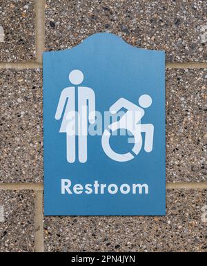 A blue sign for a public restroom signifying it can be used by men, women and handicapped people on a wall in a park in Pittsburgh, Pennsylvania, USA Stock Photo