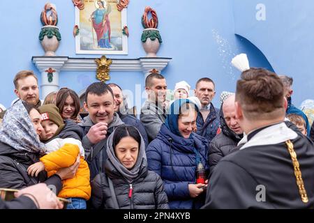 A priest blesses Ukrainian believers with Holy Water as they attend the Easter Sunday traditional celebration in St. Michael's Golden-Domed Monastery in central Kyiv. According to the tradition the faithful bring their Easter food in a basket to be purified, it is always Pasha (Easter bread), painted egg (pysanka) among other. Most of Ukrainians are Orthodox Christians or Greek Catholic Christians, both observe the eastern rite of Easter. Kyiv remains relatively peaceful as the Russian invasion continuous and Ukraine prepares for a spring counter-offensive to retake Ukrainian land occupied by Stock Photo