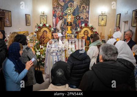 Pr. Daniel officiating the religious ceremony with the faithful who assist in silence. The faithful of the Parish of the Annunciation, the church frequented by Romanians of the Orthodox faith of Ostia Lido, participate in the ritual of the Sacred Fire. The rite of the Sacred Fire, on Holy Saturday of the Churches that follow the Julian calendar, at the height of the Easter Triduum for the Orthodox faithful from all over the world, has been taking place in the same way for at least six centuries and dates back to the Church of Constantine, in the 4th century. It is the suggestion of the flame t Stock Photo