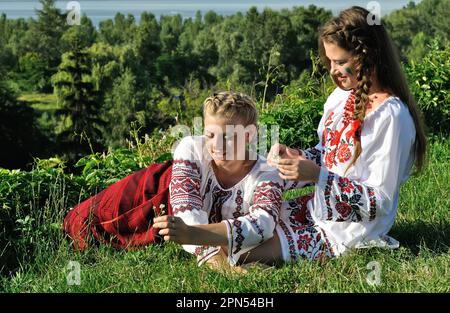 outdoor portrait of two young ukrainian women in traditional ukrainian clothes Stock Photo