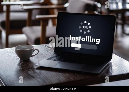 man installing Software Update On Mobile Phone And Laptop digital technology communication Stock Photo