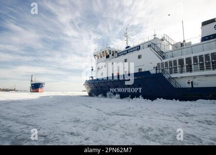 April, 2023 - Arkhangelsk. Dry cargo ship 'Bering' and icebreaker 'Captain Chaadaev'. Icebreaking operations on the Northern Dvina River. Russia, Arkh Stock Photo