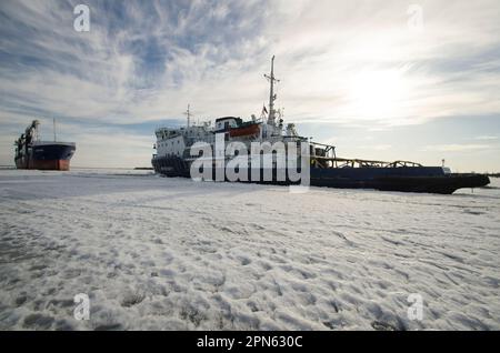 April, 2023 - Arkhangelsk. Dry cargo ship 'Bering' and icebreaker 'Captain Chaadaev'. Icebreaking operations on the Northern Dvina River. Russia, Arkh Stock Photo