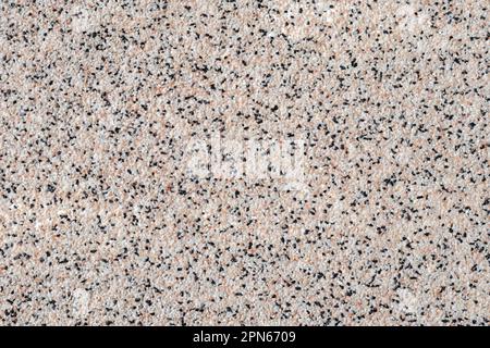 Grainy kitchen countertop top view. Surface of spotted empty table, abstract background with small black and white stones, rough material, grain light Stock Photo