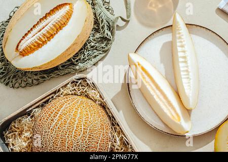 Sliced melons on a light stone background Stock Photo
