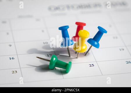 Multiple pins on one date on a calendar. Busy and fully booked schedule concept. Stock Photo