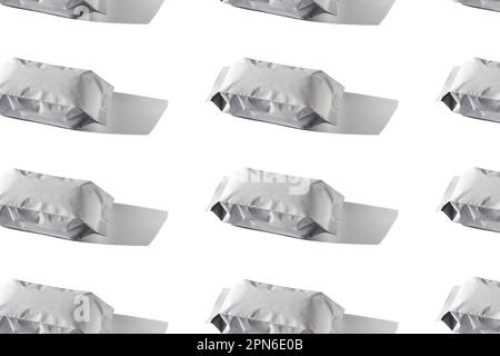 Coffee bags regular pattern. Blank white foil pouch on grey background in minimal style with natural harsh shadows. Monochrome food photo. Packaging t Stock Photo
