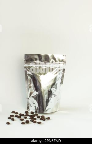 Silver metallized foil pouch bag with window isolated on white background. Aluminium metallic package for coffee beans and tea .Blank packaging templa Stock Photo