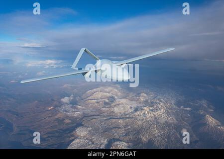 Unmanned military drone uav flying in the air, reconnaissance flight over the territory above the snow-capped mountains hills relief Stock Photo