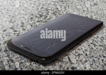 Close-up of a smartphone with a broken display, isolated on a white background Stock Photo