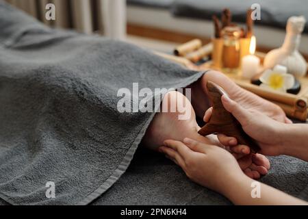 Therapist pressing points on feet of client to relief pain Stock Photo