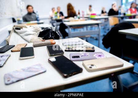 Oldenburg, Germany. 17th Apr, 2023. Numerous students' smartphones lie on a table at the Graf-Anton-Günther-Schule (GAG) before the start of the written Abitur exams in history. In Lower Saxony, the final exams for the 2023 Abitur class will begin. The exams will be written in various subjects by May 9, 2023. Credit: Hauke-Christian Dittrich/dpa/Alamy Live News Stock Photo