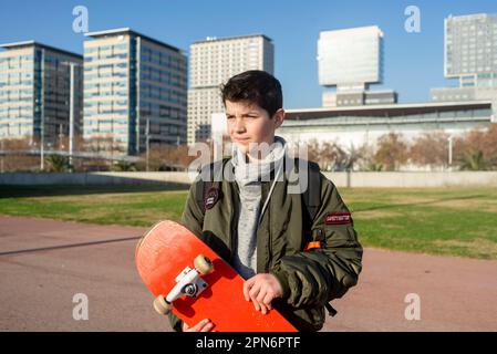 Shot of a young man holding a skateboard outside. Stock Photo