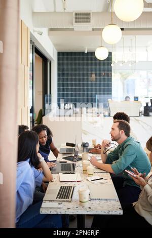 businessmen and businesswomen working on laptop sitting in coffee shop Stock Photo