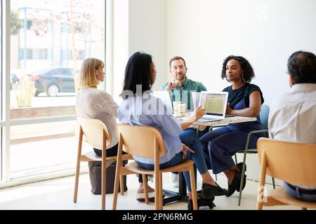 Multiracial colleagues planning strategy while sitting in cafe Stock Photo