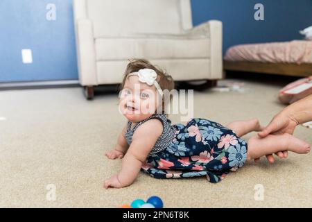 Happy special needs infant playing inside Stock Photo