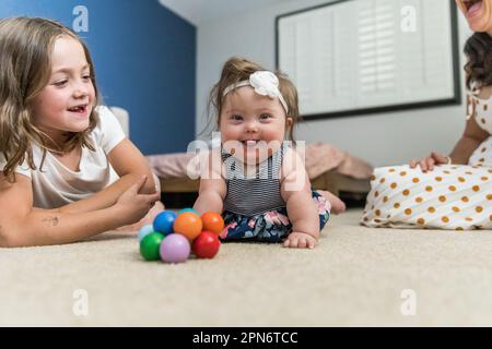 Happy baby with down syndrome playing inside Stock Photo