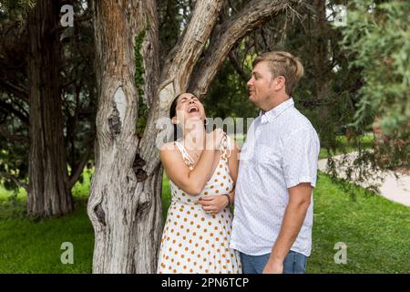 Young couple laughing and smiling outside Stock Photo