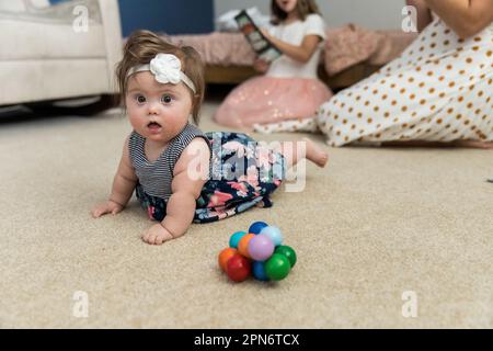 Happy girl with Down syndrome playing in playroom Stock Photo