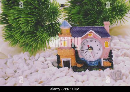 Little wax house with a clock in it Stock Photo