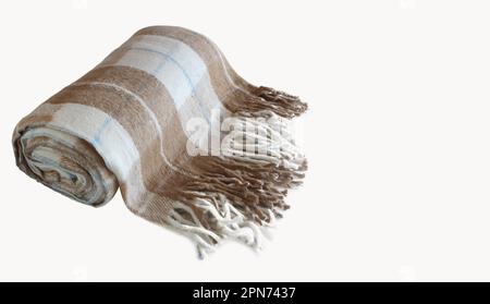 Woolen checkered plaid blanket isolated on a white background. Beige-brown rolled blanket with space for text. Close up. Stock Photo