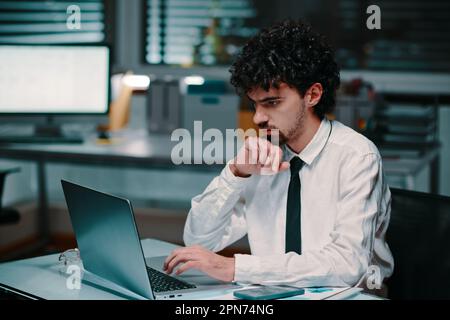Pensive businessman reading financial data on laptop screen when working on report Stock Photo
