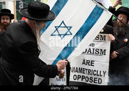 London, UK. 16 April, 2023. Ultra orthodox anti-zionist Jews from Neturei Karta set fire to an Israeli flag during the Al Quds Day march. Stock Photo