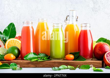 Summer beverages. Citrus fruit juices, fresh and smoothies, food background. Mix of different whole and cut fruits: orange, grapefruit, lime, tangerin Stock Photo