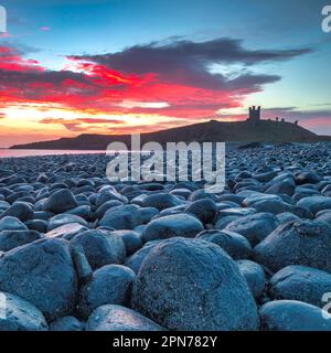 Sunrise view of Dunstanburgh Castle looking south towards Craster in Northumberland, England, United Kingdom Stock Photo