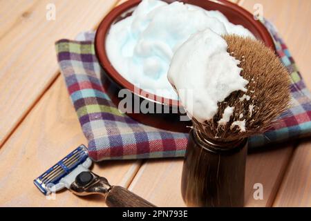 Closeup view of shaving equip, razor blade and brush and foam. Barbershop theme backgrounds Stock Photo