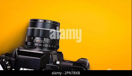 Top view of black vintage film camera isolated on yellow or orange background included clipping path. Stock Photo