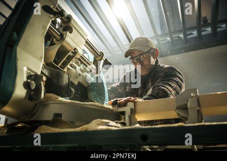 Professional Woodworker Operating a Table Saw in His Workshop. Woodworking Tools and Equipment Theme. Stock Photo
