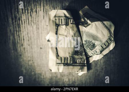 Closeup of Crumpled American Hundred Dollar Bill on Dark Background. Economics, Inflation and Money Problems Concept. Stock Photo