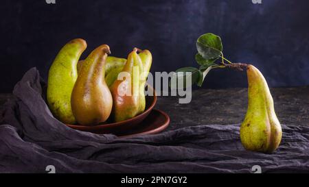 Rural still life, low key dark photography - view of pears in clay dishes, closeup with selective focus Stock Photo