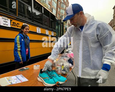 Boston, Massachusetts, USA. 17th Apr, 2023. Volunteers load runners gear on busses prior to the start of the 127th Boston Marathon. This year brings nearly 30,000 runners from more than 100 countries to run the 26.2 course from the town of Hopkinton to downtown Boston. Ten years ago a bombing at the finish line killed three and maimed scores of others. (Credit Image: © Sue Dorfman/ZUMA Press Wire) EDITORIAL USAGE ONLY! Not for Commercial USAGE! Credit: ZUMA Press, Inc./Alamy Live News Stock Photo