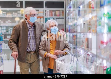 Senior couple looking for medicine in pharmacy store. Stock Photo