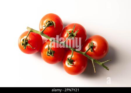 Fresh red tomatoes with green stems isolated on white background. top view. Stock Photo