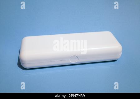 White rectangular plastic box with copy space isolated on blue. Smooth shiny case with a lid for a product mockup Stock Photo