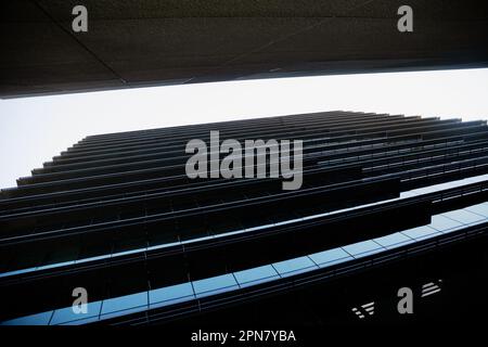 Low angle view of tall office buildings creating a beautiful geometric pattern of light and shade. Generic architecture background featuring dark skys Stock Photo