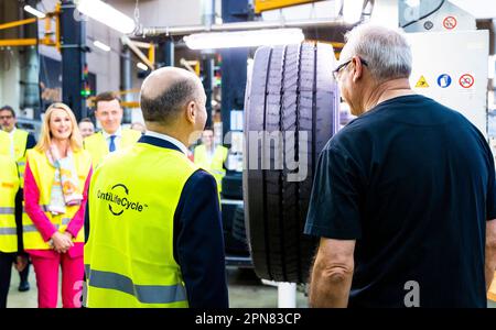 Hanover, Germany. 17th Apr, 2023. During his visit, German Chancellor Olaf Scholz (SPD, l) learns about retreading truck and bus tires from the Continental plant and talks to an employee. Credit: Moritz Frankenberg/dpa/Alamy Live News Stock Photo