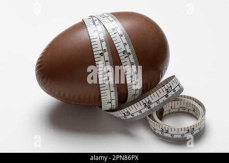 Chocolate Easter egg with tape measure in inches and cm's Stock Photo