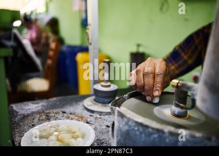 Hand of jeweler is processing Moonstone, which is mined from mine in Sri Lanka. Jewelry is made from this unique gemstones. Stock Photo