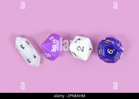 Different roleplaying RPG dice on violet background Stock Photo
