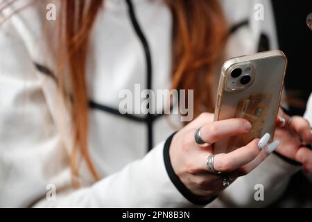 Female hand with smartphones close up. A young woman using mobile phone. Instagram, Tik Tok and Facebook. Stock Photo