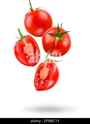 Small red cherry tomatoes floating on white background. Stock Photo